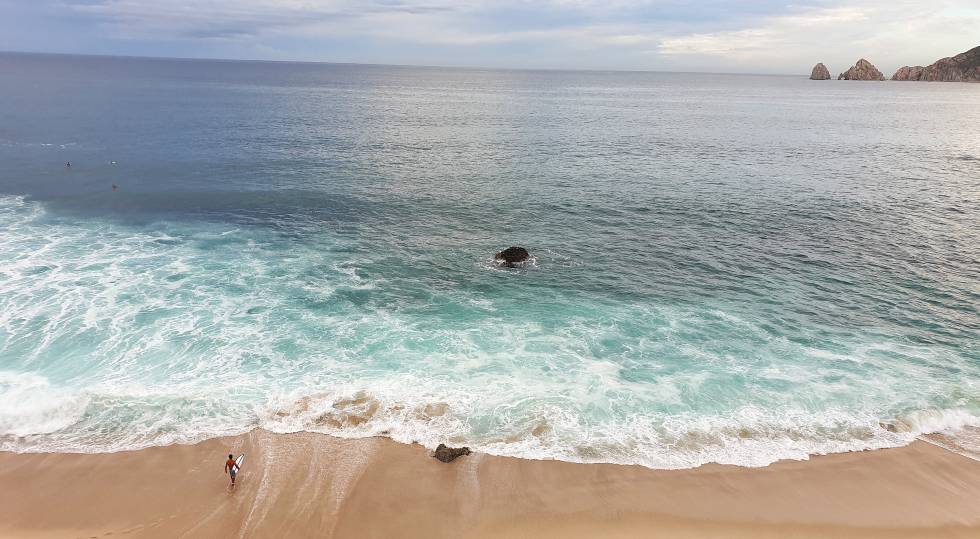 Un surfero en playa Monumento, cerca del cabo San Lucas. Al fondo de la imagen, a la izquierda, se observa El Arco.