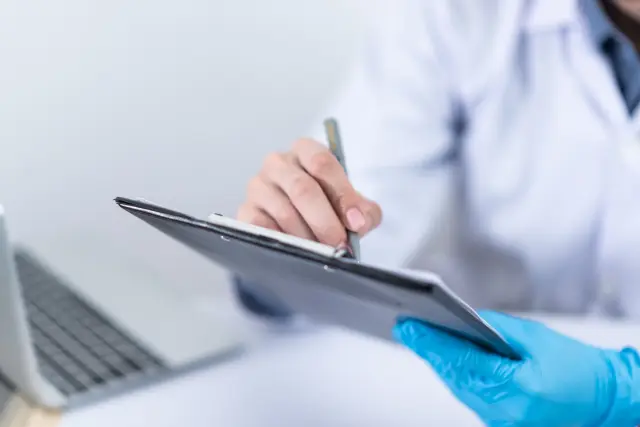 Un médico utiliza un dispositivo electrónico durante una consulta.