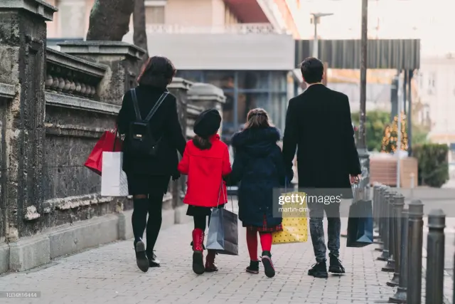 Una familia pasea por la calle.