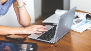 Una mujer realiza una consulta en su ordenador portátil.