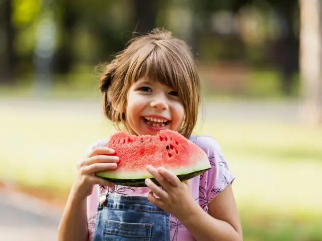 Niña sonriente comiendo una sandía