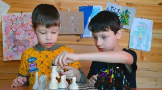 Niños jugando una partida de ajedrez.