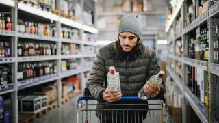 Un joven compra alcohol en una licorería